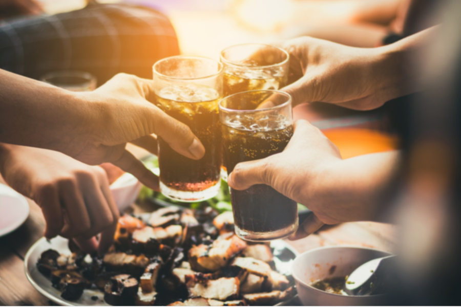 duas mãos seguram dois copos com bebidas