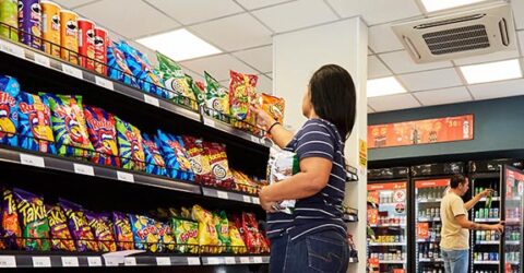 mulher pegando produto em mercado