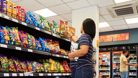 mulher pegando produto em mercado